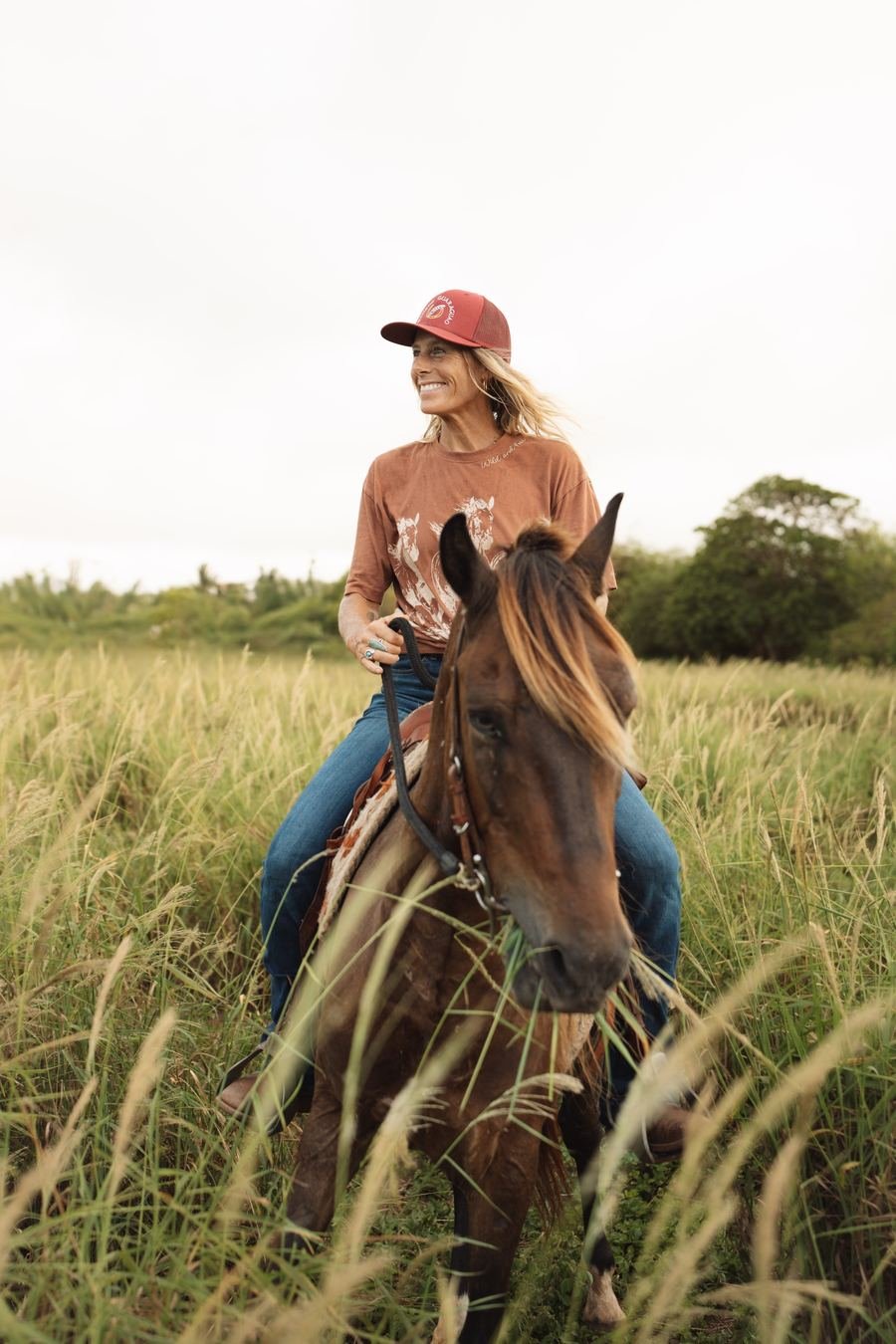 Horseback riding through tall golden grass at Rancho Guaraguao in Isabela, Puerto Rico